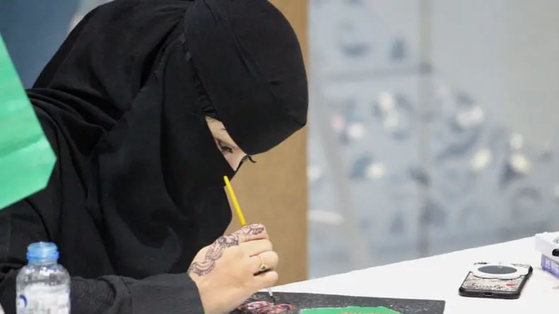 هدى الصيخان.. فنانة سعودية تتحدى إعاقتها بالرسم على القصدير 
